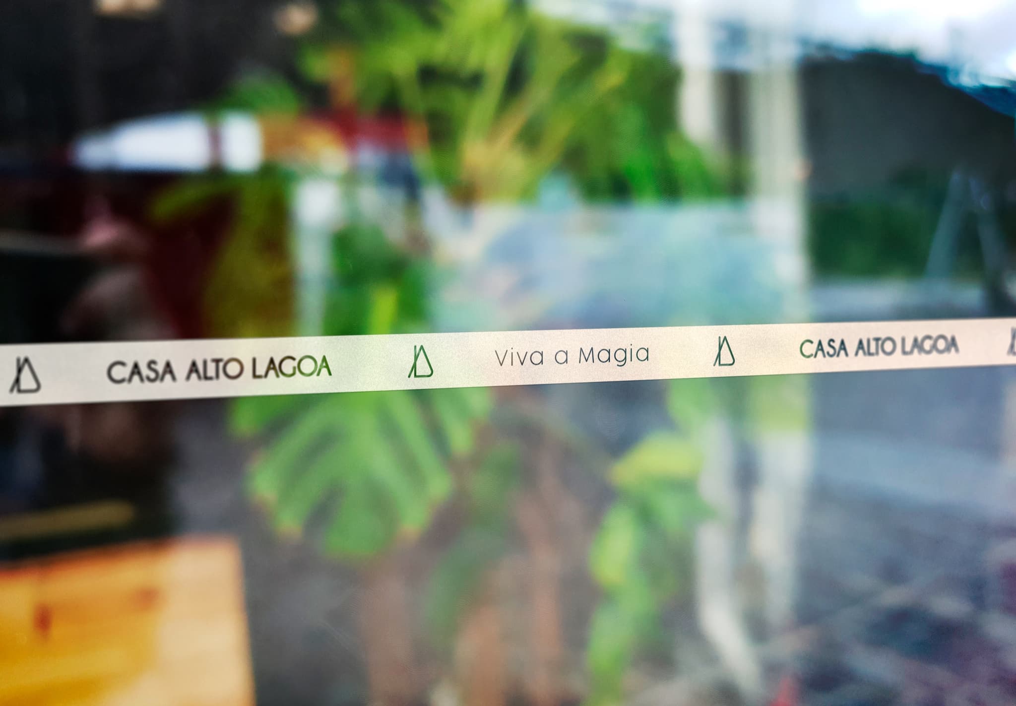Faixa adesiva com a marca e a assinatura Viva a Magia aplicada no vidro