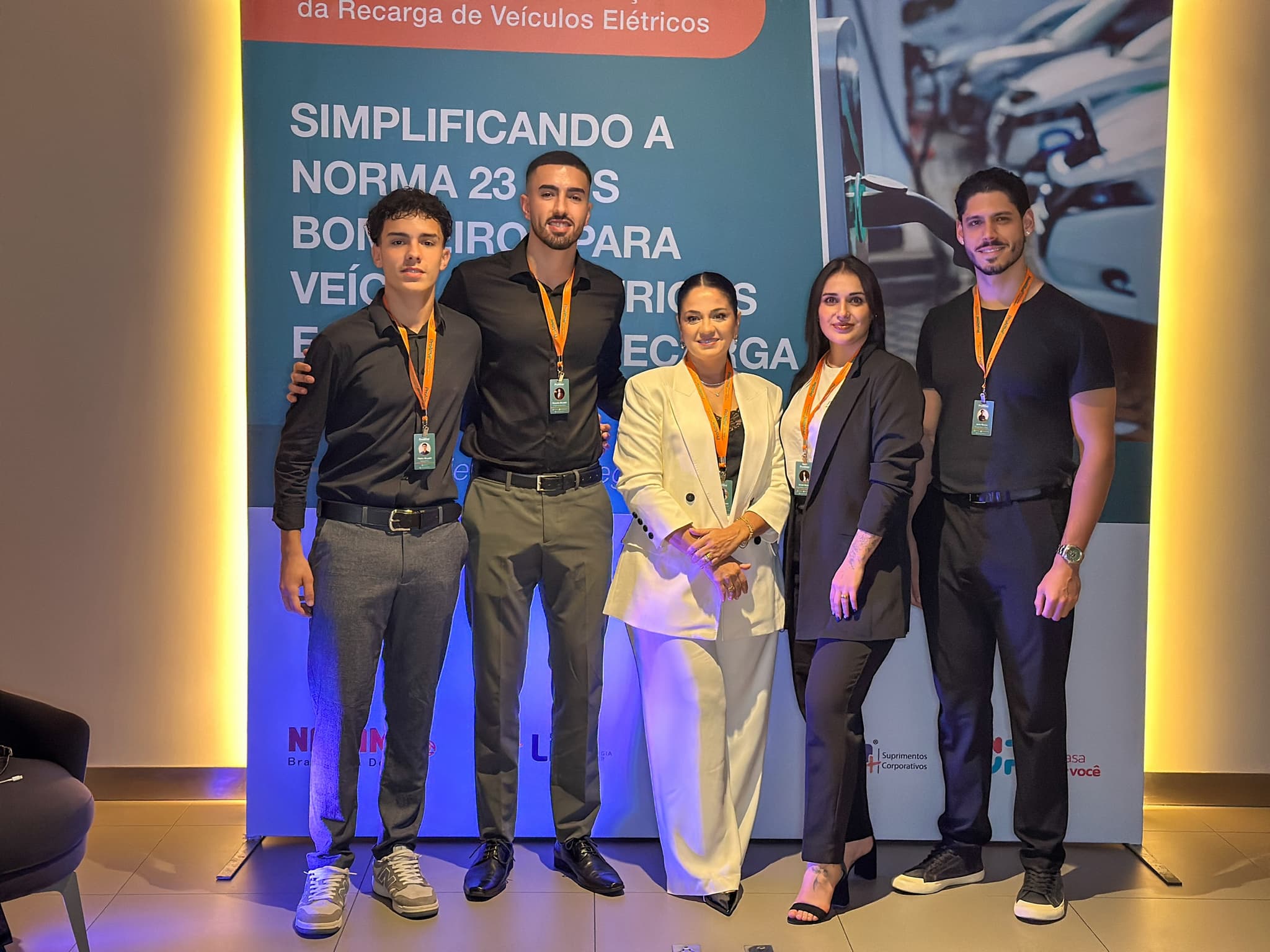 Equipe de organização do fórum reunida em frente ao painel do evento