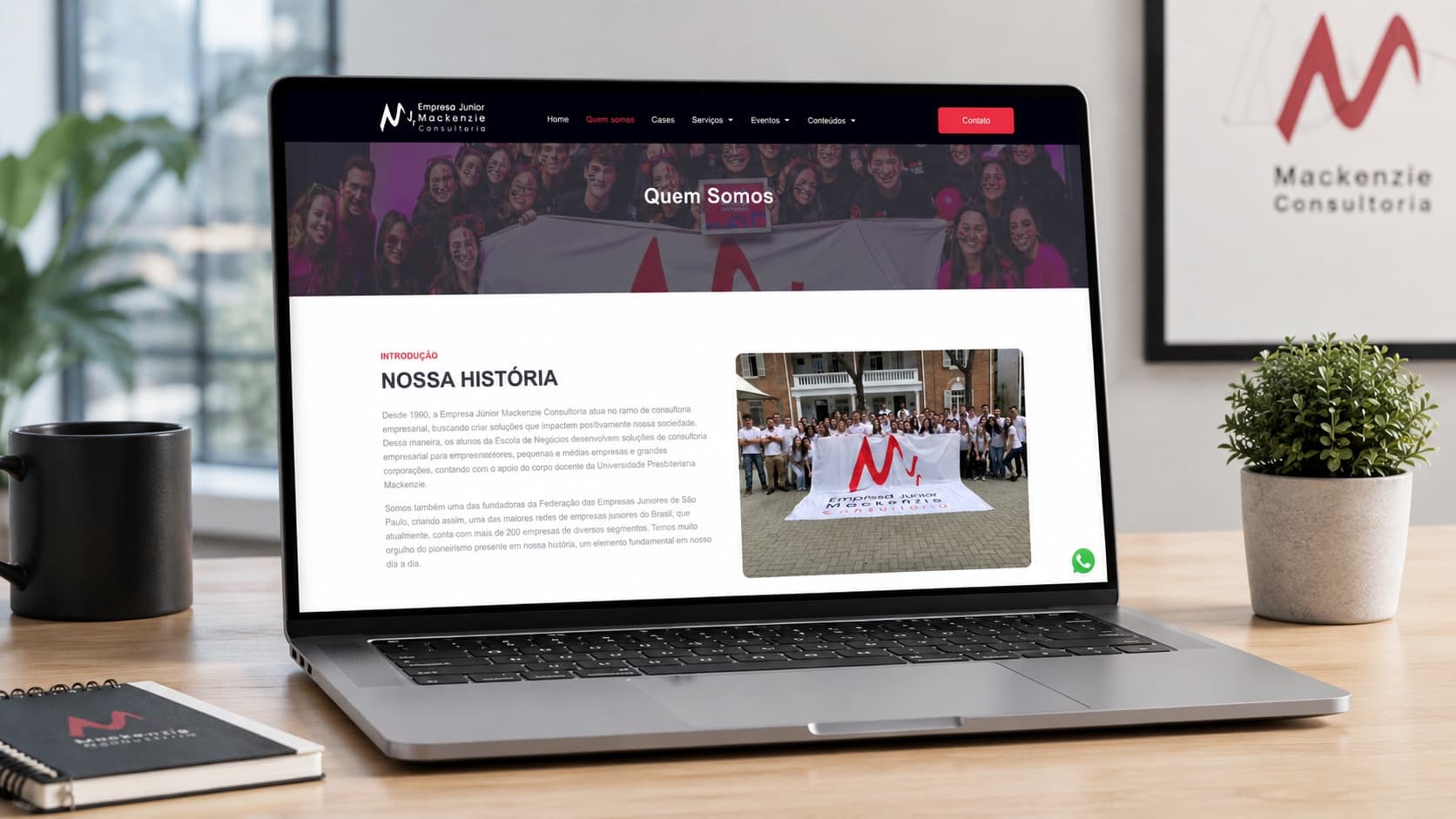 Notebook com a página Quem somos do site da Empresa Júnior Mackenzie Consultoria sobre uma mesa clara