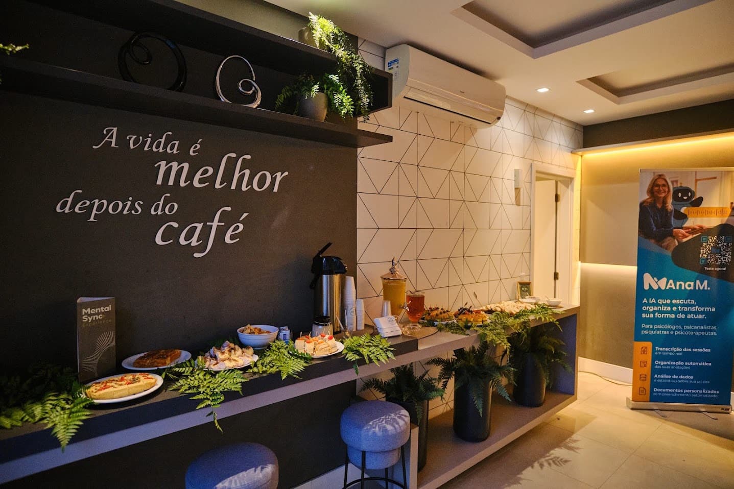 Coffee do lançamento Mentalsync com banner da Ana M e mesa de hospitalidade