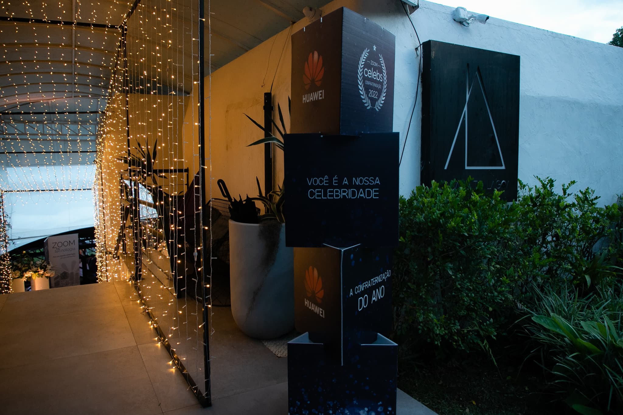 Entrada do evento com cortina de luzes e painel Você é a nossa celebridade