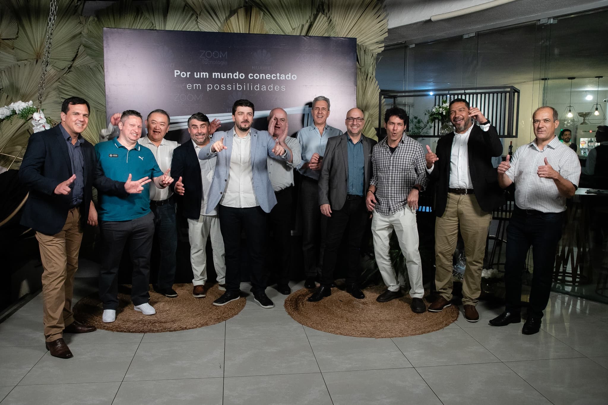 Grupo de colaboradores posa diante do painel de fotos Por um mundo conectado em possibilidades